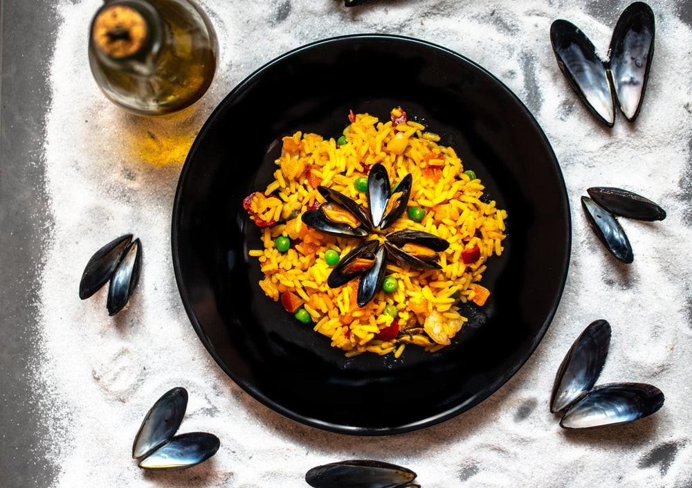 A Dish Containing Paella with Beans and Mussels