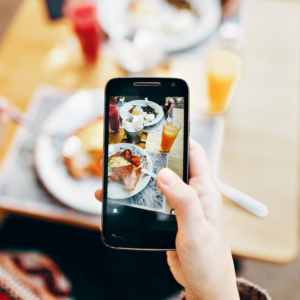 A food blogger taking a picture of served food