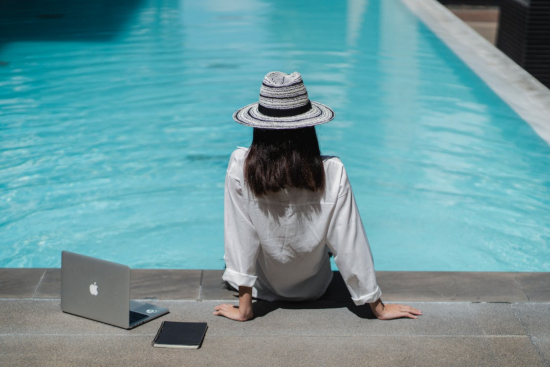 A travel blogger sitting by the pool