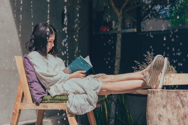 a girl reading a book outside