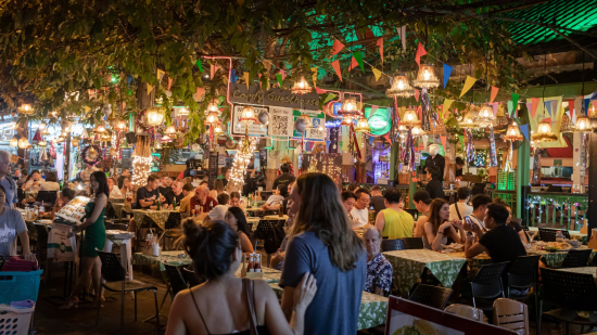crowds of people gathered to enjoy street food at open-air eateries and the nightlife Irina Bukatik